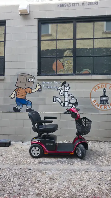 Accessible visit to a box-man cartoon mural with a mobility scooter rental, Kansas City