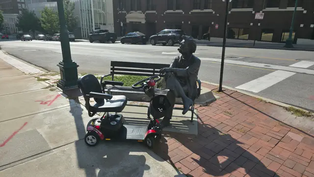 Mobility scooter rental on location at a bronze bench sculpture, Kansas City