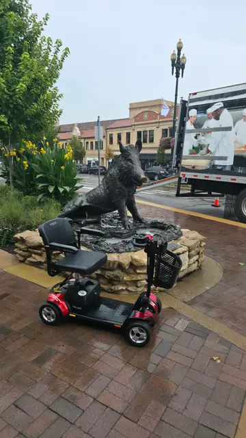 Mobility scooter from KC Mobility at a bronze wolf sculpture in Kansas City