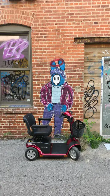 Mobility scooter rental at a character mural on brick, Kansas City