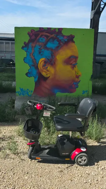 Mobility scooter rental on location at a face profile mural, Kansas City