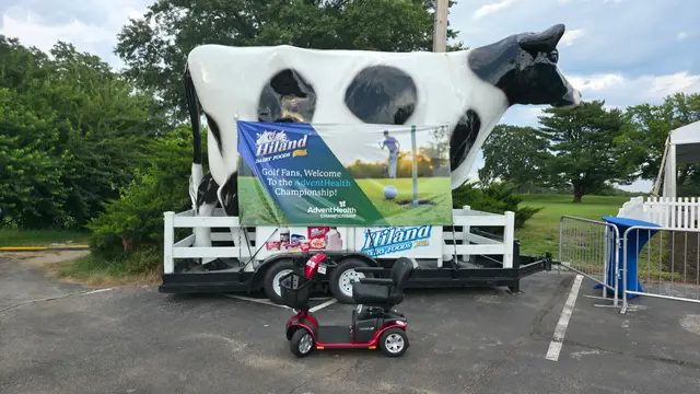 Mobility scooter from KC Mobility at a giant cow sculpture in Kansas City