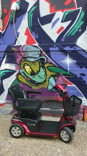 Accessible visit to a green creature mural with a mobility scooter rental, Kansas City