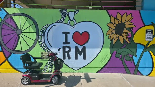 Mobility scooter rental at an i heart river market mural, Kansas City