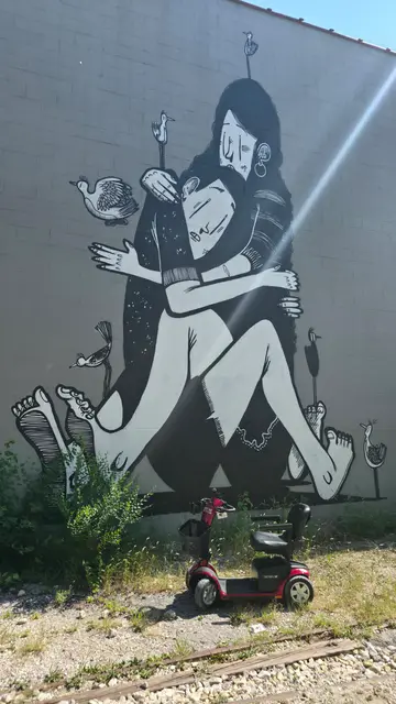Mobility scooter rental on location at a monochrome figure mural, Kansas City