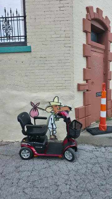 Mobility scooter from KC Mobility at a mouse character mural in Kansas City