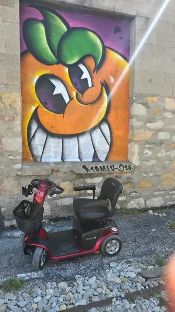 Mobility scooter rental at an orange smile mural, Kansas City