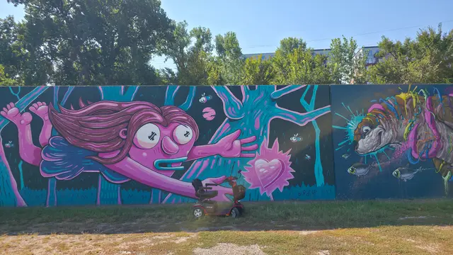 Accessible visit to a pink creature mural with a mobility scooter rental, Kansas City