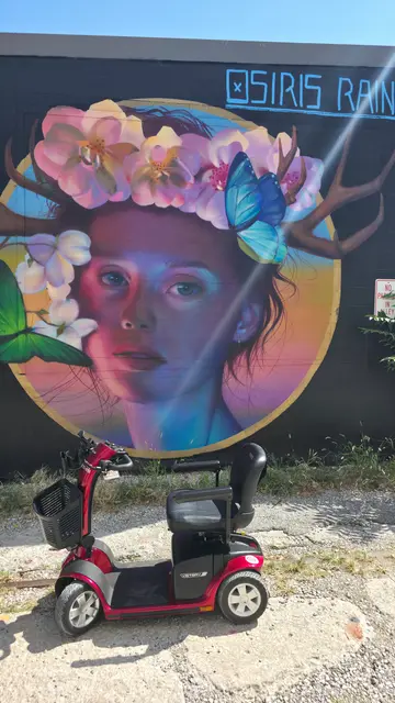 Mobility scooter from KC Mobility at a portrait mural with butterfly in Kansas City