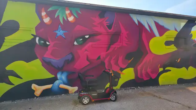 Mobility scooter rental on location at a red demon mural, Kansas City