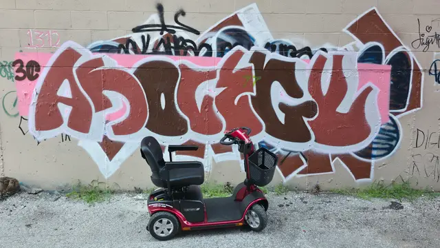 Mobility scooter rental on location at a red graffiti piece, Kansas City