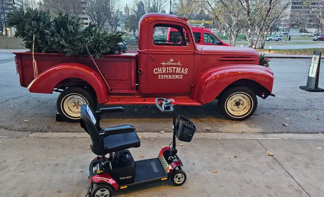 Accessible visit to a vintage red truck with a mobility scooter rental, Kansas City