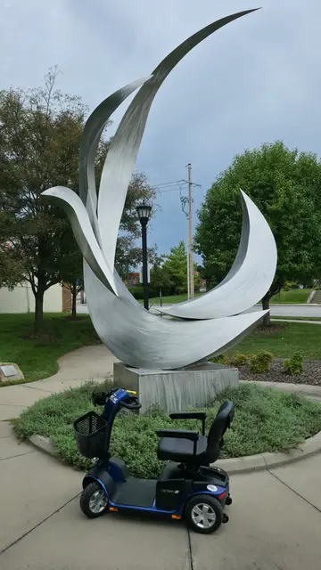 Mobility scooter from KC Mobility at a white curved sculpture in Kansas City