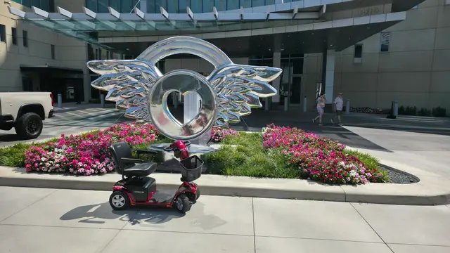 Mobility scooter from KC Mobility at a winged heart sculpture in Kansas City